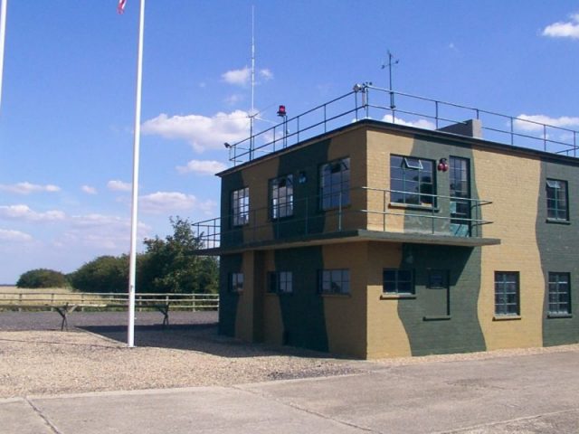 RAF Twinwood Control Tower restored in 2002. It contains a tribute to Major Alton Glenn Miller who took his final flight from here on December 15, 1944. Photo by MilborneOne CC BY SA 3.0