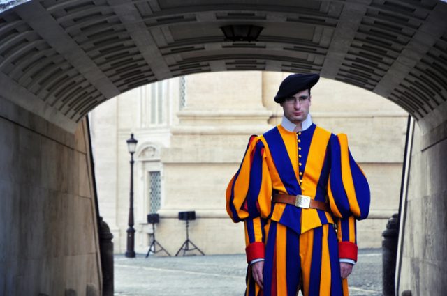 Vatican City – May 3, 2013: Member of the Pontifical Swiss Guard in his traditional uniform standing at the entrance into St. Peter’s Basilica in Vatican City State, Rome, Italy.