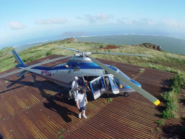 Navy contractors from PMRF arrive at Paniau Ridge on Ni’ihau in an Agusta A109 helicopter. The seabird sanctuary island of Lehua can be seen in the background.