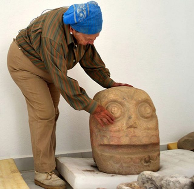 Archaeologist Castillo with one of the sculptures. MELITÓN TAPIA/INAH