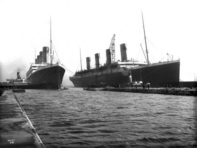 Olympic (left) being manoeuvred into dry dock in Belfast for repairs on the morning of March 2, 1912 after throwing a propeller blade. Titanic (right) is moored at the fitting-out wharf. Olympic would sail for Southampton on March 7th, concluding the last time the two ships would be photographed together.