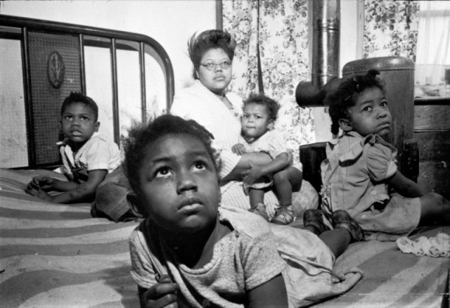 African American mother and her four children in their tenement apartment, 1949. Photography by S. Kubrick.