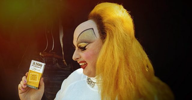 American actor and singer Harris Glenn Milstead as character Divine smiling showing a lice shampoo on the set of the film Pink Flamingos. 1972. (Photo by Mondadori Portfolio via Getty Images)