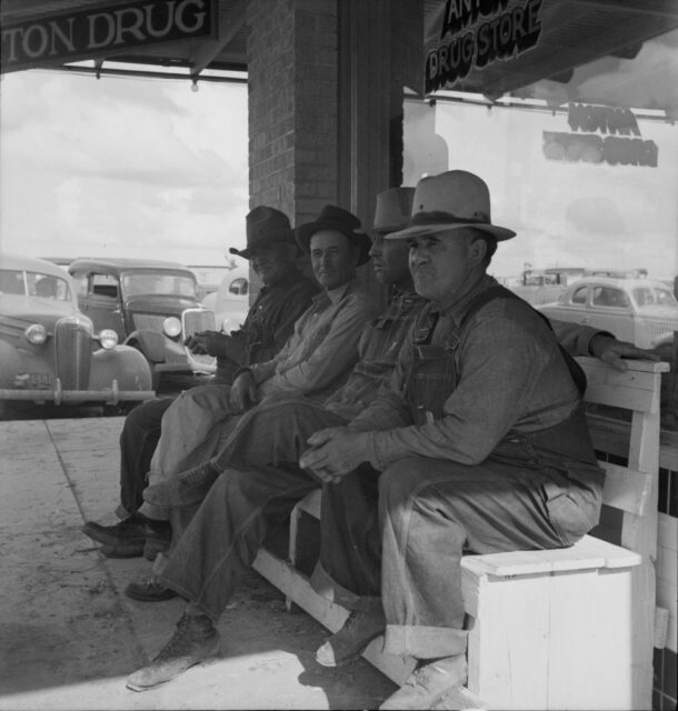 Farmers sit in front of a store