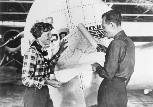 Pilot Amelia Earhart and her navigator, Fred Noonan, with a map of the Pacific that shows the planned route of their last flight. Photo by Getty Images