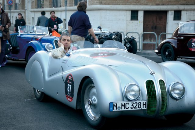 Rome, Italy – May 14, 2011: Actor Rowan Atkinson drives a vintage BMW 328 Mille Miglia Roadster (1939) in the historical Mille Miglia race for classic cars. Photograph taken in Rome, near Castel sant’Angelo.