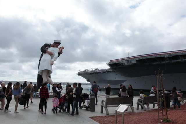 San Diego, California USA – May 27, 2018: Tourists visit Unconditional Surrender Statues and USS Midway Museum in San Diego, California