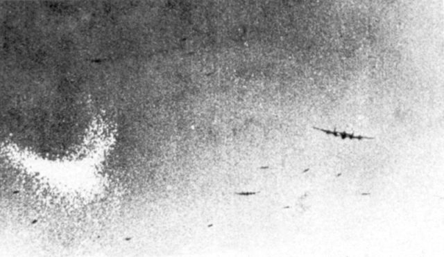 A Lancaster dropping chaff (the crescent-shaped white cloud on the left of the picture) over Essen during a thousand-bomber raid.