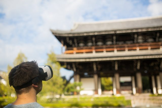 Man using virtual reality headset at a Japanese temple. Kyoto, Japan. December 2016