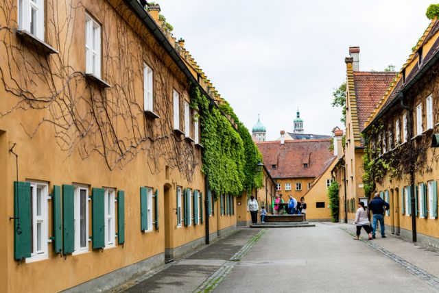 May 20, 2018: visitors near the well in the Fuggerei, Augsburg. Augsburg is a city in Swabia, Bavaria – it is the third oldest city in Germany.