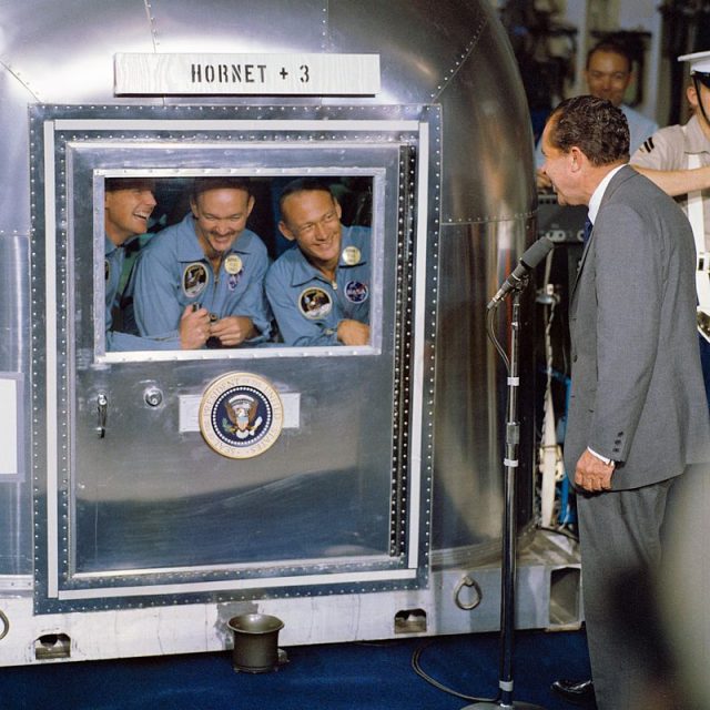 The crew of Apollo 11 in quarantine after returning to Earth, visited by Richard Nixon