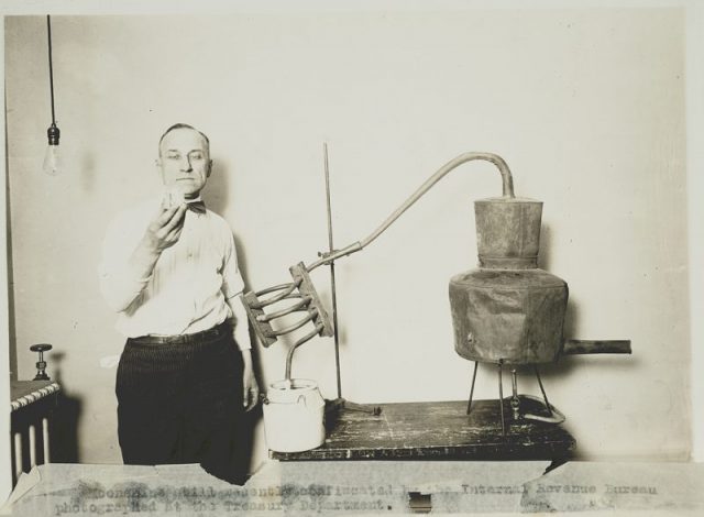 1930s Internal Revenue Bureau inspects the contents of a recently confiscated moonshine still