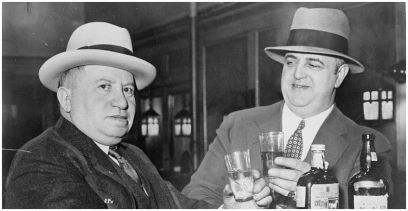 Izzy Einstein and Moe Smith, former police officers during Prohibition, sharing a toast in a New York Bar. 1935