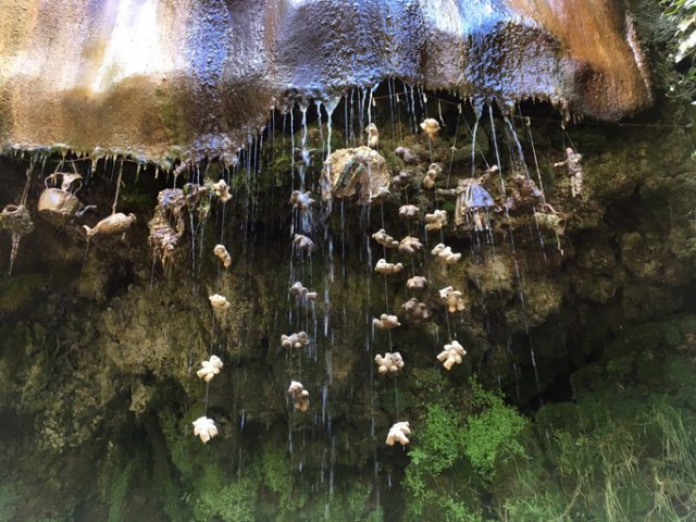 Knaresborough, England – July 16, 2016: Everyday objects have been hung in the water of the Petrifying Well, slowly being covered by minerals. The Petrifying Well is the oldest tourist site in the UK.