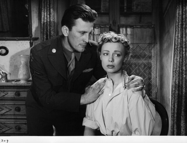 Kirk Douglas holding Dany Robin's shoulders in a scene from Act of Love