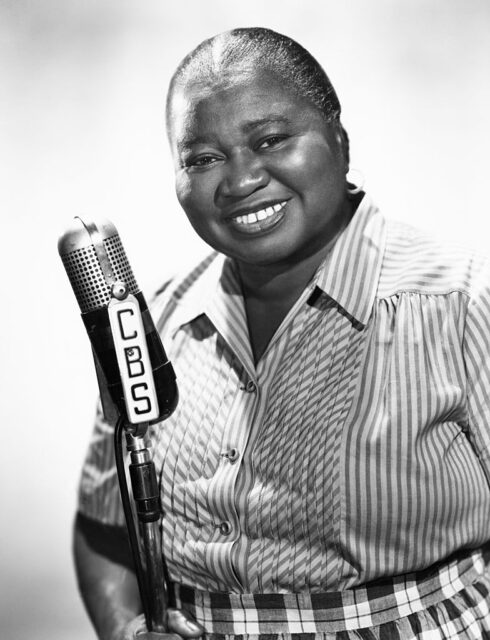 Hattie McDaniel standing with a microphone