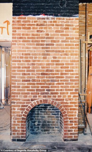 Behind one of the sheetrock walls, a brickwork fireplace was discovered with soot still in the chimney. Credit: Segretis Hospitality Group