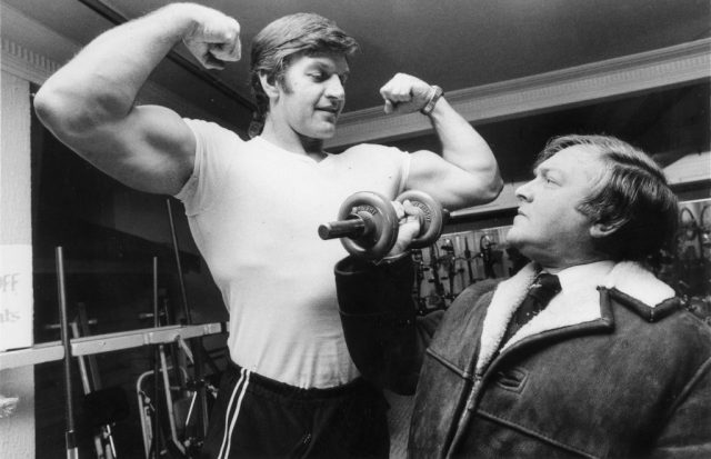 13th January 1978: A potential client admires Dave Prowse who works in the keep-fit department of Harrods. He also plays the role of Darth Vader in Star Wars. (Photo by Colin Davey/Evening Standard/Hulton Archive/Getty Images)