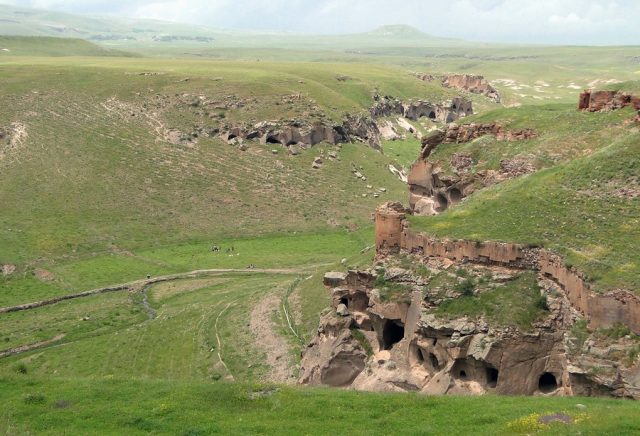 A gorge below Ani, showing numerous caves dug into cliffs, as well as fortifications. Adam Jones – CC BY 2.0