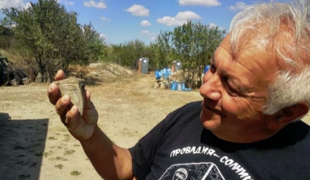 Prof. Vasil Nikolov is seen here showcasing the mouthless clay mask from the 5th millenium BC.. Credit: Bulgarian National Radio