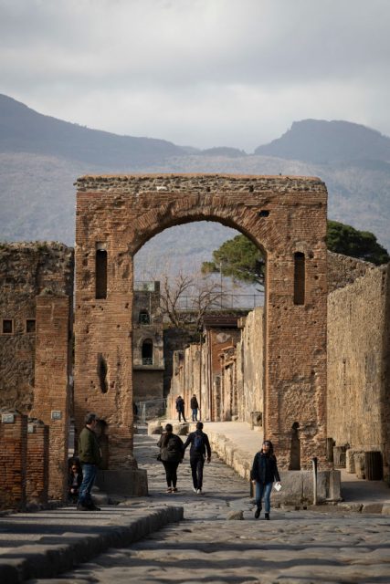 A woman walks past a statue in the Forum at the Pompeii Archeological Park. Getty Images