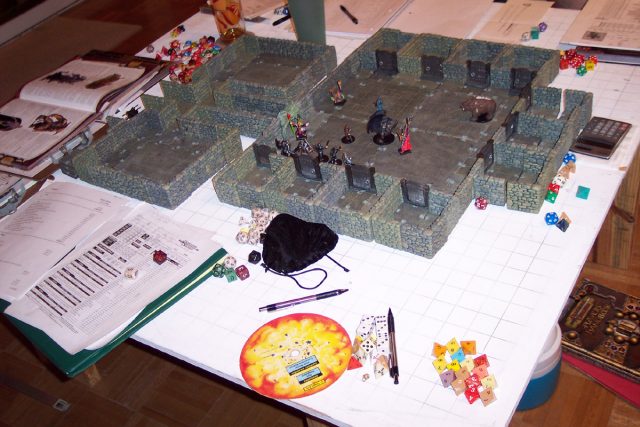An elaborate D&D game in progress. Among the gaming aids here are dice, a variety of miniatures and a dungeon diorama. Philip Mitchell – CC BY-SA 3.0