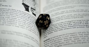 A 20-sided die sits in the pages of a D&D book