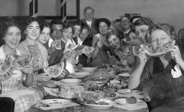 people eating watermelon at dinner party