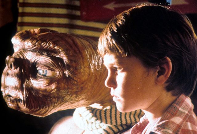 E.T and Henry Thomas staring out a window in E.T. The Extra-Terrestrial