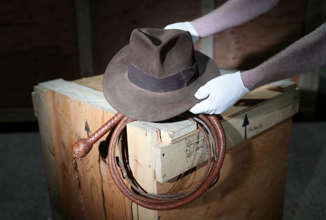 A Prop Store employee adjusts the Fedora and Bullwhip as used by Harrison Ford in Raiders of the Lost Ark and Indiana Joes and the Temple of Doom respectively, while on display at the Prop Store head office near Rickmansworth ahead of the Entertainment Memorabilia Live Auction on 20th September.