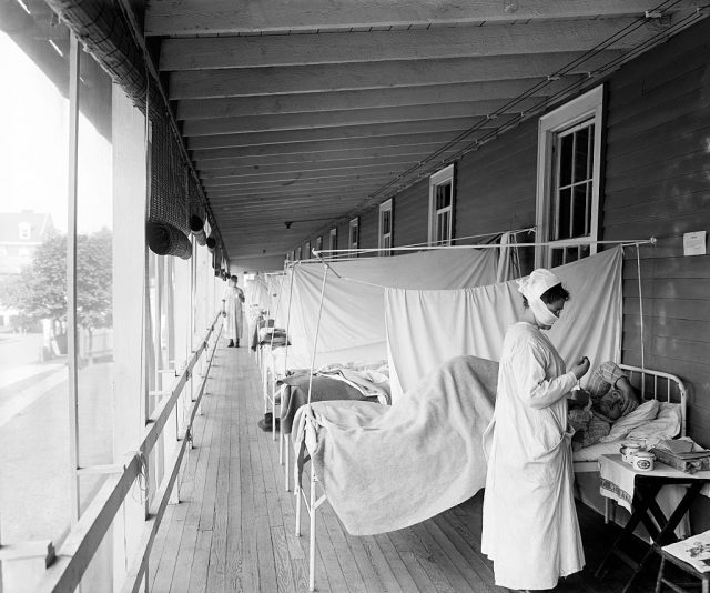 A nurse standing next to a patient in the Flu Ward of Walter Reed Hospital