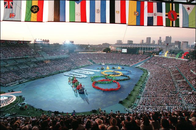 Overhead view of Centennial Olympic Stadium filled with people, with the Olympic Rings in the center