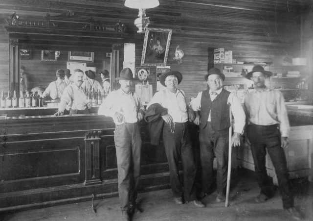 Four men and a bartender at a Saloon in the American West