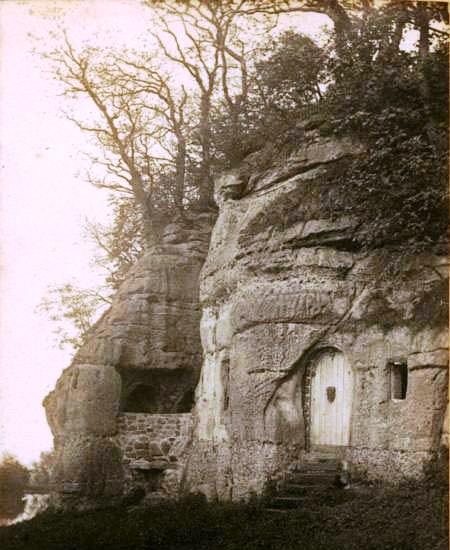 Exterior of the Anchor Church Cave with a white door in the entrance