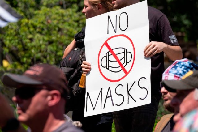 Protestor holding an anti-mask sign