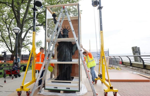 Workmen uncrate the "Little Sister" of the Statue of Liberty, a 9-foot-tall bronze statue, crafted from the original 1878 plaster model by Auguste Bartholdi as it is put on display at Ellis Island on July 1, 2021 in New York City. 