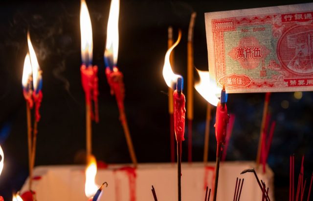 A resident burns paper money during the festival.