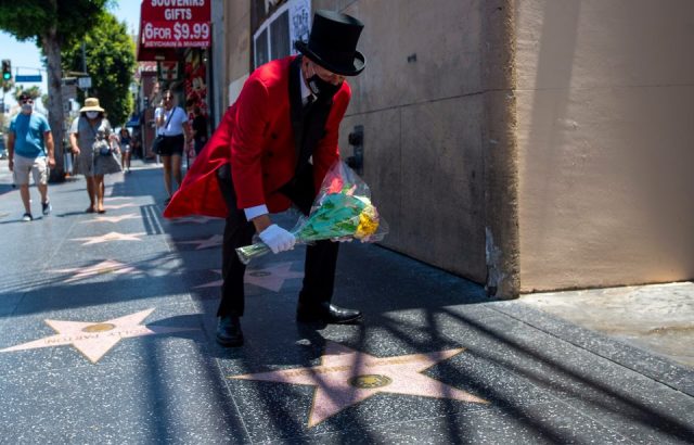 Gregg Donovan, who goes by The Ambassador, places flowers on the Hollywood Walk of Fame star of director Richard Donner, who died Monday at age 91.