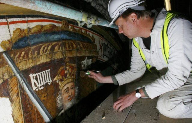 Conservator Peter Austen carries out the finishing touches of his restoration of King Arthur's famous Round Table in Winchester's Great Hall. 