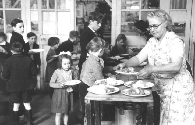 1950s school lunch. Children line up to be served