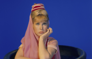 Barbara Eden as Jeannie in front of blue background