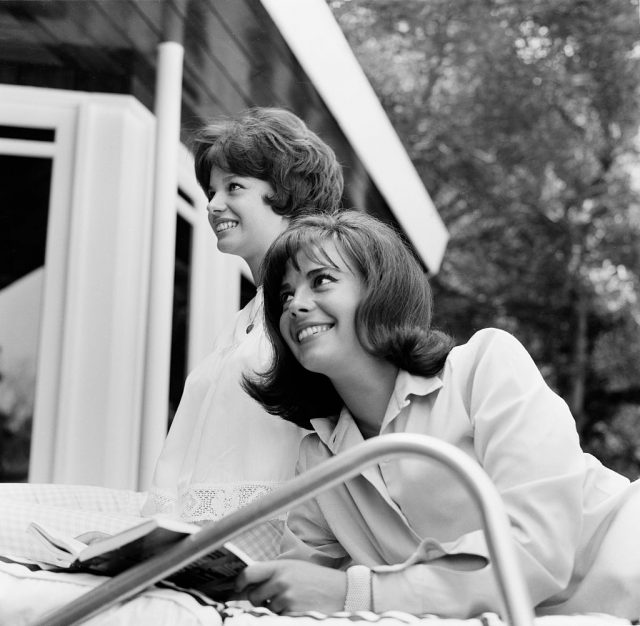 Natalie and Lana Wood sitting on the edge of a pool