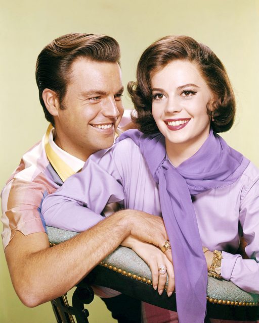 Robert Wagner smiling at Natalie Wood, who is wearing a purple ensemble