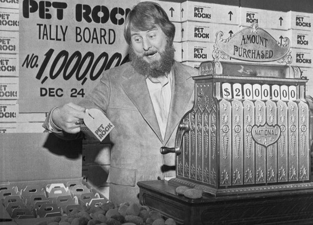 Gary Dahl standing behind a cash register with boxes of pet rocks