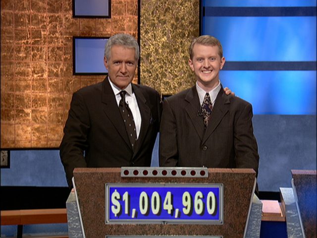 Alex Trebek and Ken Jennings standing behind a podium