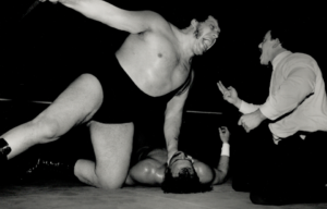 Andre The Giant yellsat the referee during a match