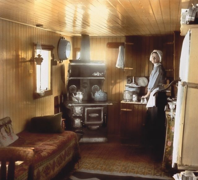 Woman standing in a 1910s kitchen