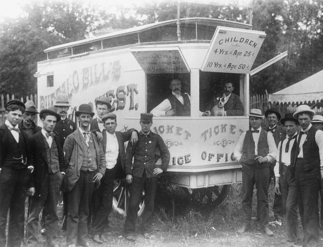 Men posing around a ticket booth for Buffalo Bill's Wild West Show