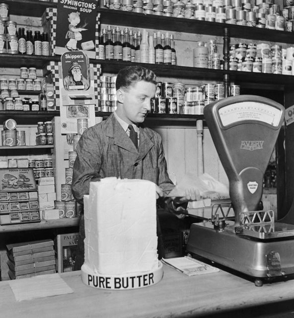 A grocer weighs a slab of butter in his shop, 1942. (Photo Credit: Bill Brandt/Picture Post/Hulton Archive/Getty Images)