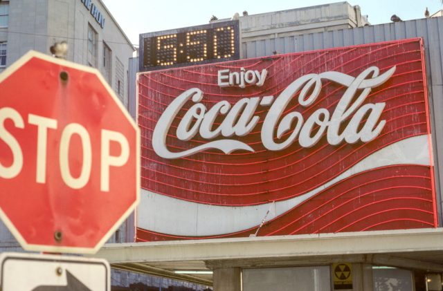 Coca-Cola sign behind a stop sign